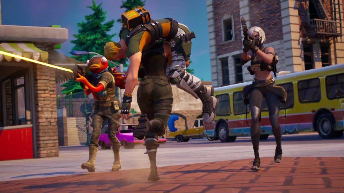 A still from a trailer for Fortnite Reload. It shows two players giving another two players cover as one runs carrying the other on its shoulders.